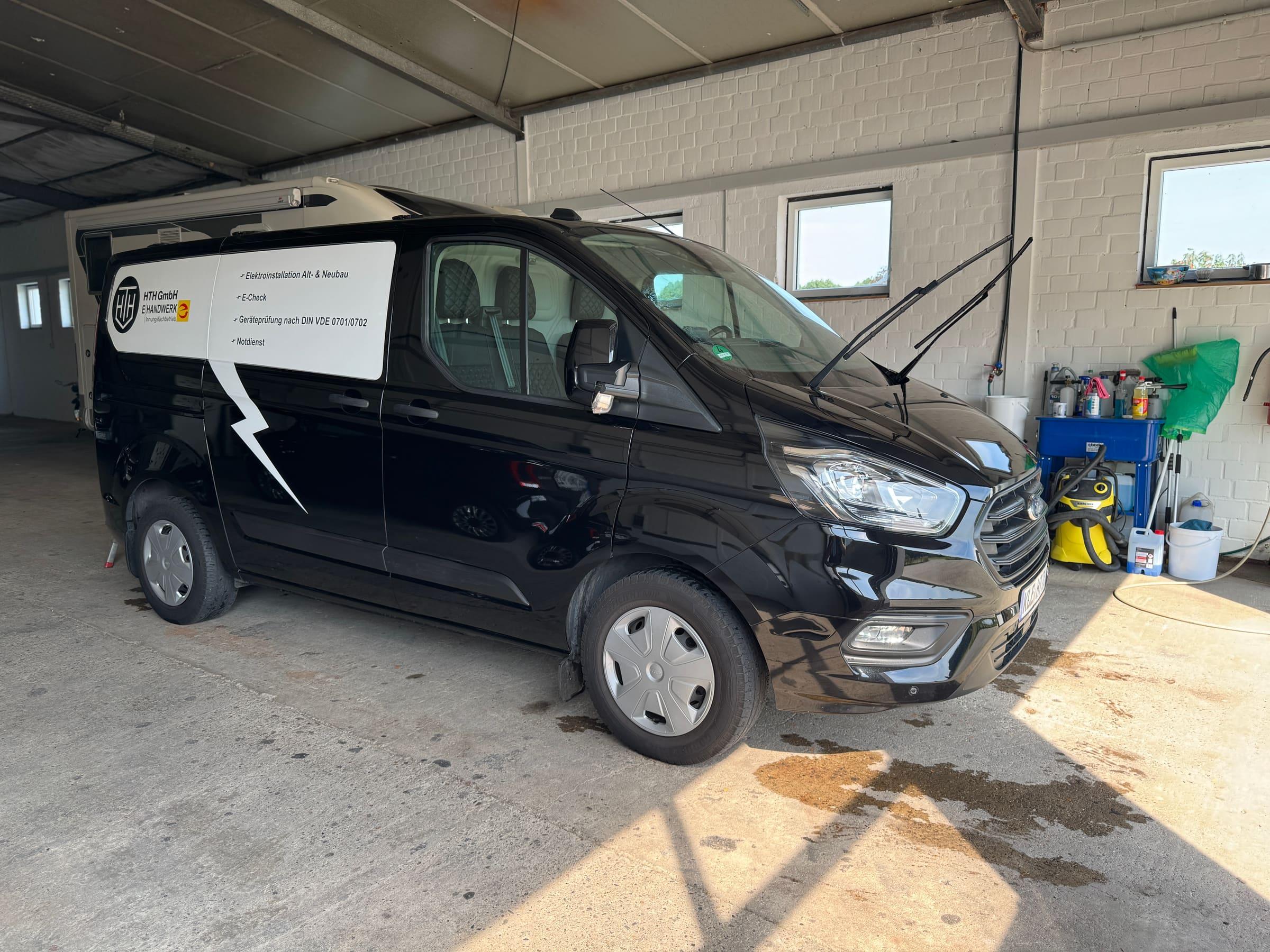 Frisch aufbereiteter schwarzer Transporter in der Halle von AB Fahrzeugpflege